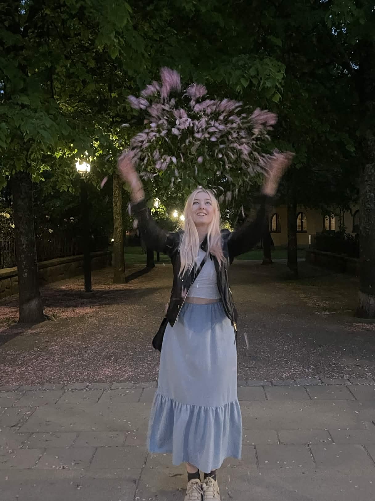 Portrait of Denise Heijkenskjöld tossing cherry blossoms